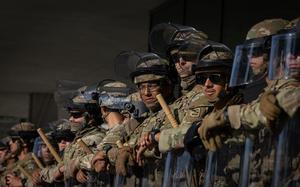 Men hold riot shields near a building in Los Angeles, California.