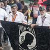 Korean War Army veteran Rafael Gomez and Vietnam veteran Javier Morales present the Prisoner-of-War-Missing-in-Action flag during a down-pour at the start of a Veteran Day celebration event in Catano, Puerto Rico, on Saturday, Nov. 11, 2017.