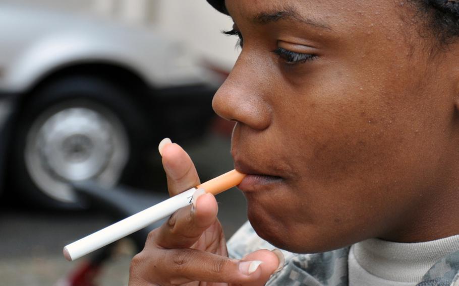 Pfc. Lashaun Coward, stationed in Bamberg, Germany, tries an e-cigarette for the first time while on a smoke break Friday. Her verdict: "What is the difference between it and a real cigarette?"

