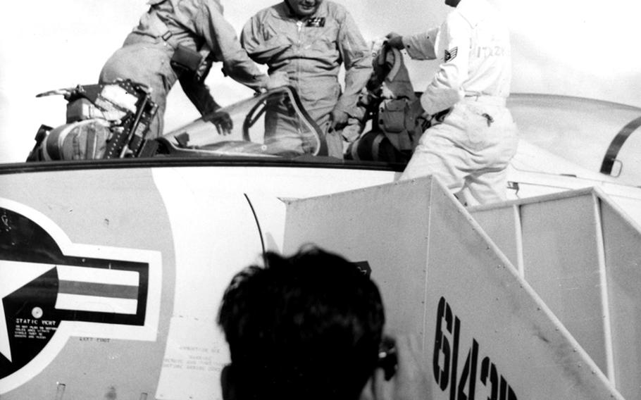 Rep. Daniel Inouye (D-Hawaii) emerges from the cockpit of an F9F8T jet trainer at Itazuke Air Base, Japan, in 1960. Inouye and the plane's pilot, Maj. Robert H. Klingman, left, flew in from Tokyo so the congressman could visit his ancestral home at nearby Yokoyama.