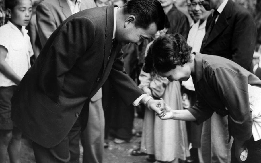 Rep. Daniel K. Inouye (D-Hawaii) is welcomed to his ancestral village of Yokoyama, Japan, by a relative in 1960.