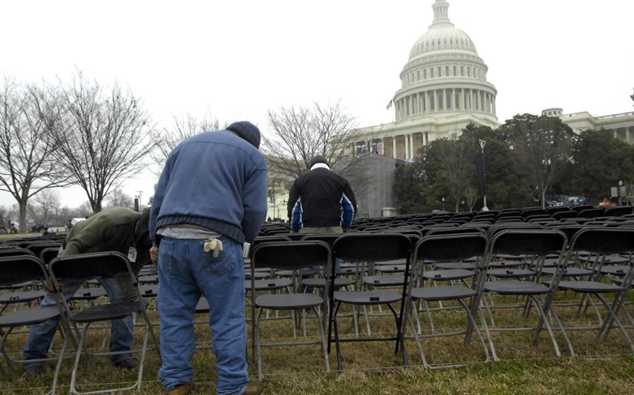 Workers set up chairs on the Capitol lawn during Sunday's inaugural rehearsal.