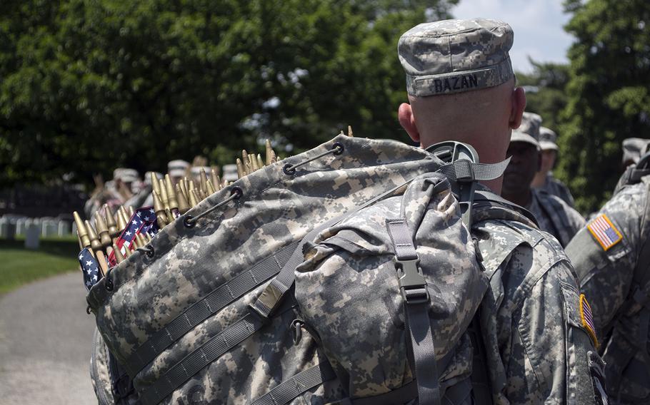 A soldier carries a bag containing some of the more than 200,000 flags that were planted during the "Flags In" event at Arlington National Cemetery on May 22, 2014.