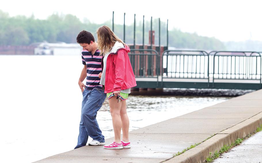Jacob Sullivan holds on to Elizabeth Gordon as he dips his foot into the water at the Ohio riverfront on April 13, 2015, in Paducah, Ky. The Ohio River in Paducah was measured at 36.62 feet on Monday. At this location the flood stage, when the water level rises enough so that it is considered a flood event, is set at 39 feet. 