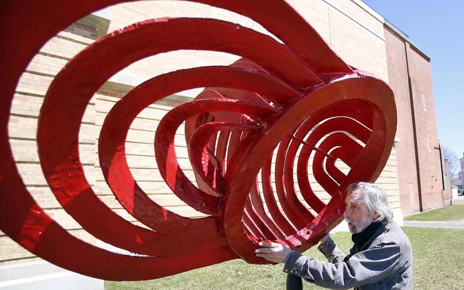 Sculptor Ze'ev Willy Neumann installs his new sculpture titled "Tip of the Hat" outside of the Colonial Theatre on April 15, 2015, in Pittsfield, Mass. The work is one of five new sculptures that will be installed throughout Pittsfield as part of the city's 2015-2016 Artscape exhibit. 