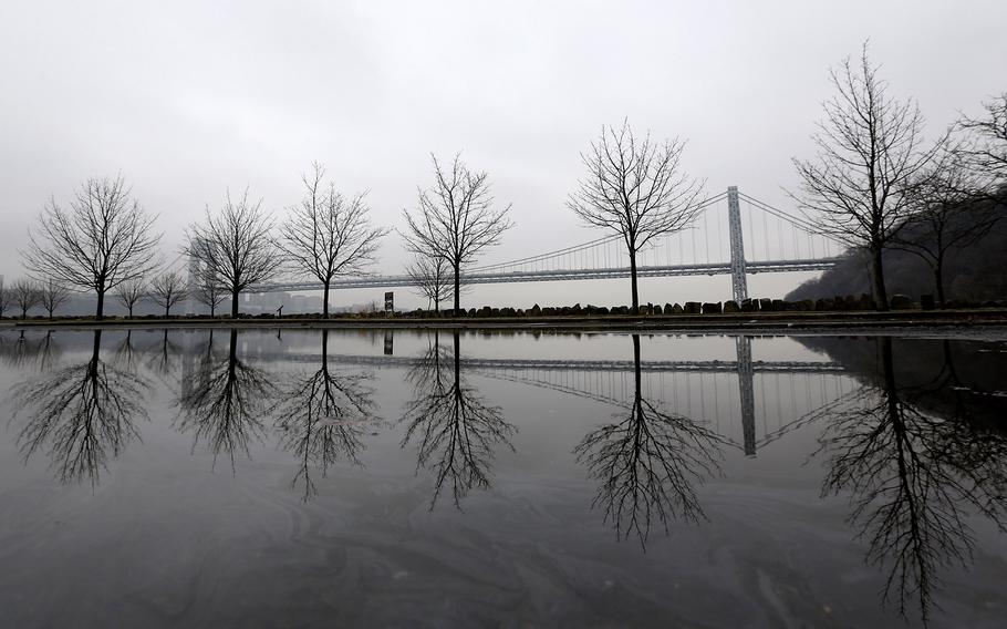 Trees and the George Washington Bridge are reflected on accumulated rainwater at Palisades Interstate Park on a foggy day on April 10, 2015, in Fort Lee, N.J. 