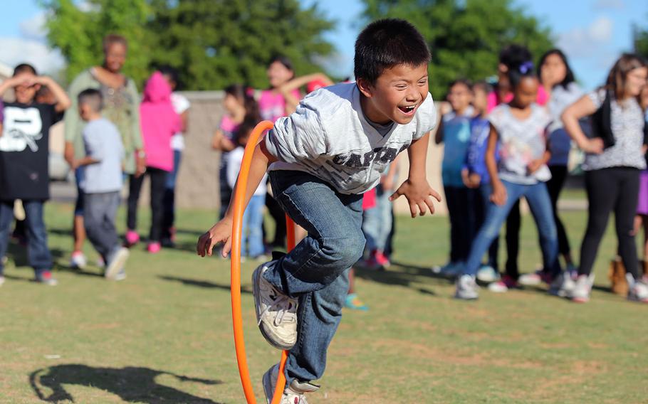 Nine-year-old Alejandro Henderson jumps through a hula hoop during a game on April 14, 2015 at the ROCrageous Sidewalk Ministry at La Promesa Apartments in Odessa, Texas. The sidewalk ministry is an outreach program for Housing and Urban Development housing sites around Odessa which promotes worship and offers a full service while participating in games with the children in the housin areas. 