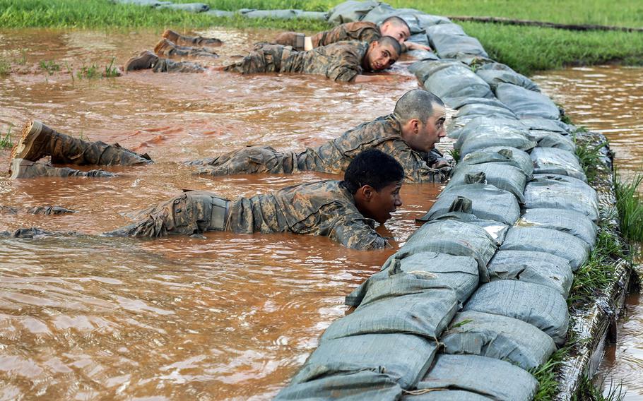In this file photo from April 21, 2015, U.S. Army soldiers negotiate the Darby mile and an obstacle course during the Ranger Course at Fort Benning, Ga.