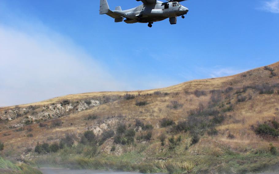 An MV-22 Osprey hovers over Pulgas Lake on Thursday at Camp Pendleton, Calif., as part of a training exercise preparing military and civilian authorities to fight wildfires in San Diego County this summer. Though the Osprey hasn't typically been used to fight fires in the past, it could be called on to assist by loading up a massive bucket of water and dumping it on the flames.