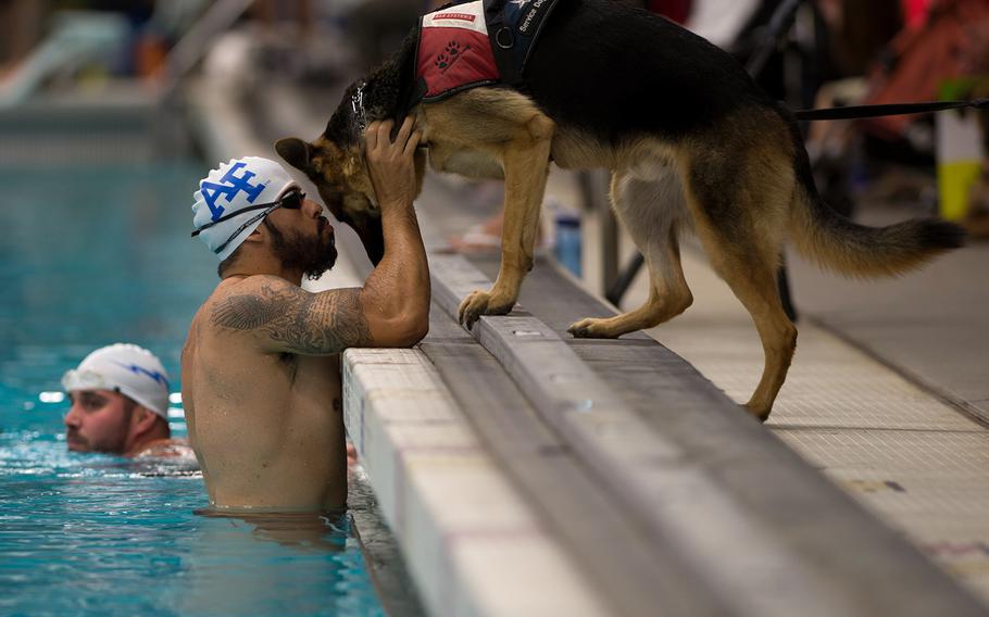 Air Force athlete August O'Niell kisses his service dog, Kai, during warmups for the swimming portion of the 2014 Warrior Games Sept. 30, 2014, at the U.S. Olympic Training Center in Colorado Springs, Colo. The Warrior Games consist of athletes from the Defense Department, who compete in Paralympic-style events for their respective military branch.
