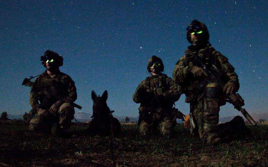 Rangers from Headquarters Company, 3rd Battalion, 75th Ranger Regiment and a multi-purpose canine pause during a nighttime combat mission in Afghanistan on March 6, 2012.