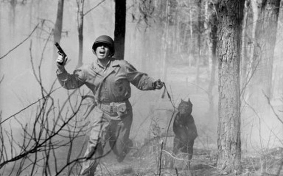 The Devil Dog Charge: Marine Pvt Michael PiPoi, of Needham, Mass., and his Devil Dog partner, charge through the smoke of battle during training at the War Dog Detachment School, Camp Lejeune, N.C., in March 1943.