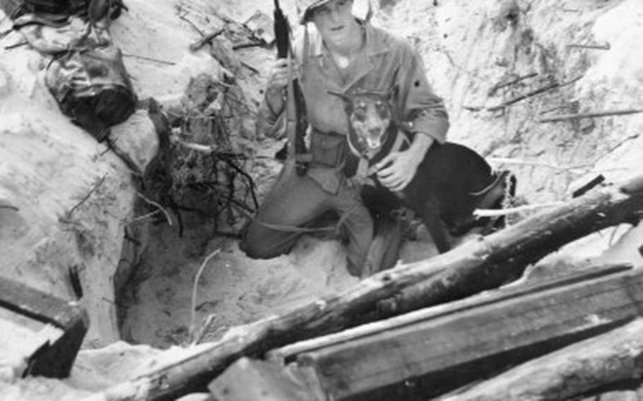 Foxhole buddies: Ready for action in their foxhole on Peleliu, are Marine Corporal William R. Scott of Greensboro, N.C., and his Doberman-Pinscher War Dog, “Prince.”