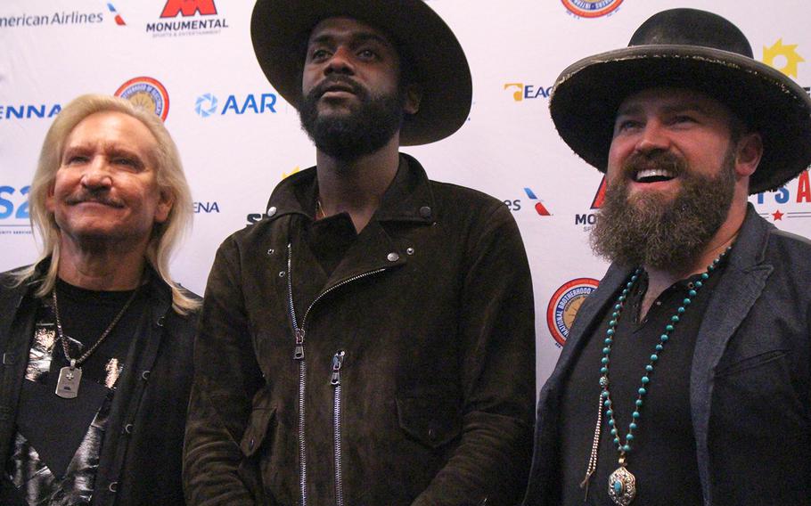 Joe Walsh, Gary Clark Jr. and Zac Brown pose for photos before the start of VetsAid, at Eagle Bank Arena, Wednesday, Sept. 20, in Fairfax, Va.