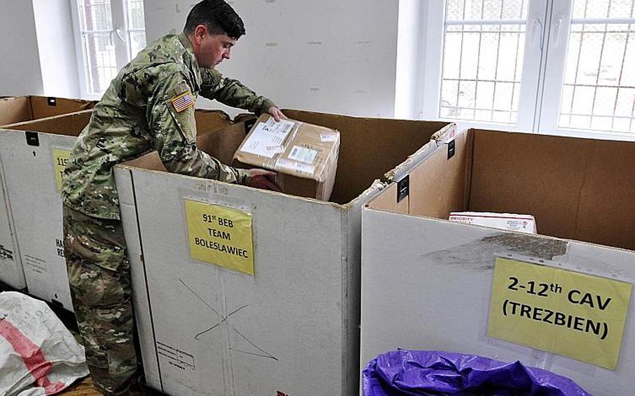 Postal clerk Spc. Thomas Gallen places a package into a receiving company's outbox in Zagan, Poland, June 26, 2018.