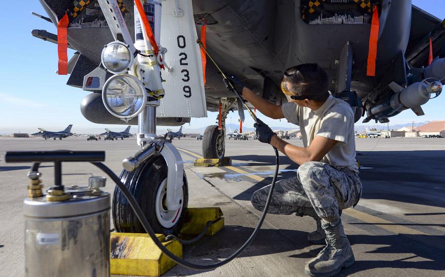 Airman 1st Class Bonifacio Garcia, 757th Aircraft Maintenance Squadron, cleans a F-15E landing gear at Nellis Air Force Base, Nev., in November 2018.