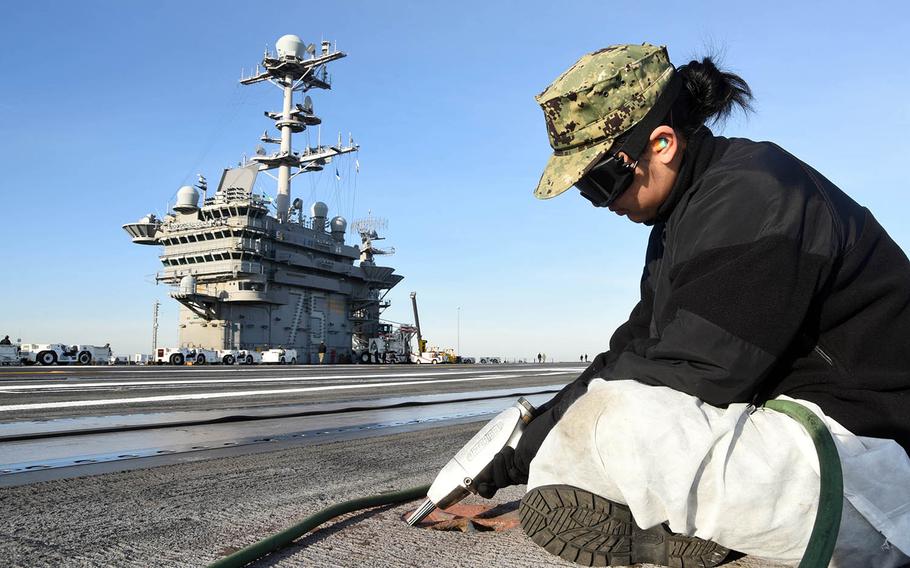 A sailor performs maintenance on the flight deck of the aircraft carrier USS Harry S. Truman at Norfolk, Va., March 13, 2019.