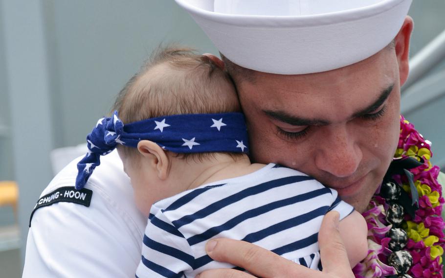 Petty Officer 1st Class David Andrews hugs his 3-month-old daughter Bailey for the first time, May 31, 2019, at Joint Base Pearl Harbor-Hickam, Hawaii. She was born while his ship, the USS Chung-Hoon, was on a seven-month deployment.