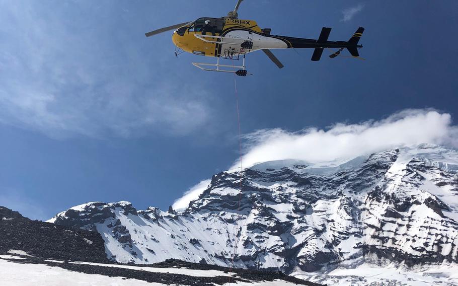 A Mt. Rainier National Park Service rescue helicopter uses a ''short haul'' technique to transfer an injured climber from an accident site at 10,400 feet on Liberty Ridge to a staging area on the north side of Mount Rainier, May 30, 2019. Bill Dean, 45, a former special operations soldier instrumental in the fight against the Islamic State group, died recently during a climb along the ridge.