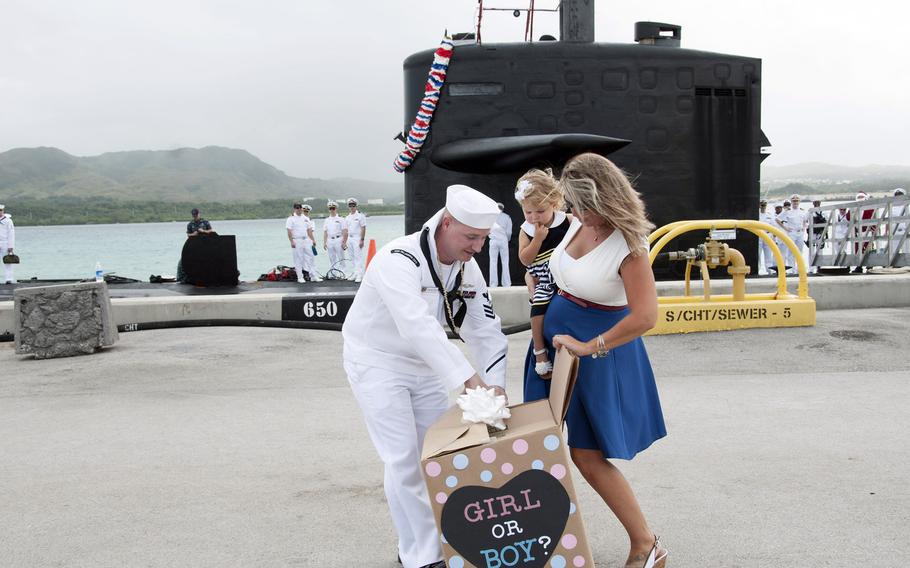 Jennifer Atkins gives a baby gender reveal to her husband, Petty Officer 1st Class Jonathan Atkins, on the pier at Apra Harbor, Guam, during a homecoming celebration for the submarine USS Oklahoma City in December 2016. Two recent studies differ on whether men on submarines father girls significantly more often than they do boys.