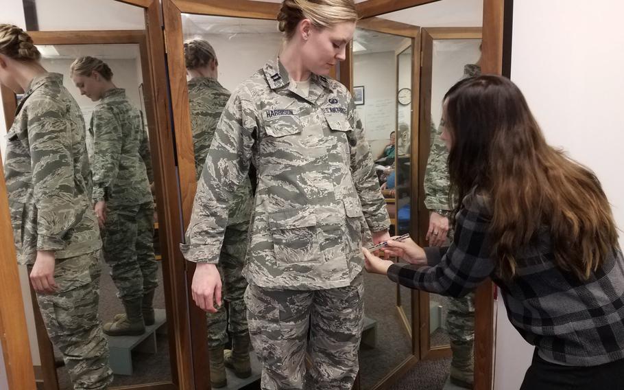 Stacey Butler, right, a clothing designer with the Air Force Life Cycle Management Center's Air Force Uniform Office, measures Capt. Taylor Harrison's maternity Airman Battle Uniform in 2017. The Air Force is seeking feedback on its maternity uniforms through an online survey.