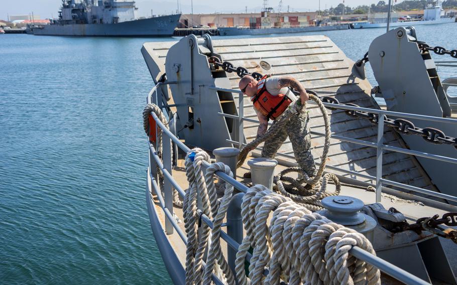 A 481st Transportation Company (Heavy Boats) soldier works the lines as the Landing Craft Utility 2000 disembarks from Port Hueneme, Calif., in 2015. The Army has suspended plans to shut down its watercraft units and auction off ships while while a congressional review is ongoing.