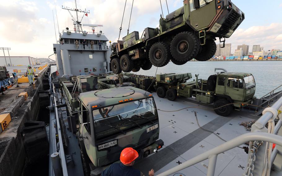 An M984A4 Heavy Expanded Mobility Tactical Truck is lowered onto a Landing Craft Utility (LCU) 2010 at Naha Military Port in Okinawa, Japan, in January 2019. The Army has suspended plans to shut down its watercraft units and auction off ships while while a congressional review is ongoing.