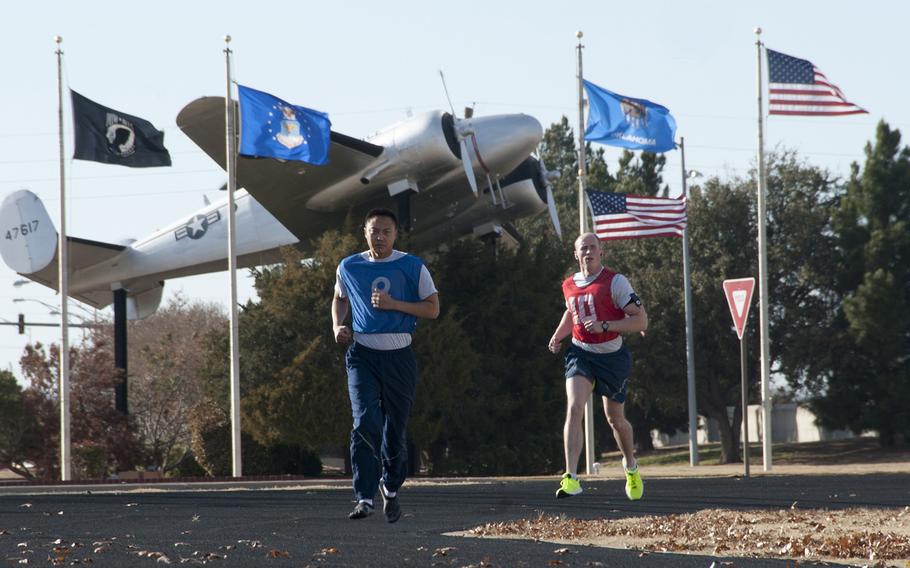 Airmen run during a physical training test at the base track at Altus Air Force Base, Okla. in 2013. The PT test consists of four components: a 1.5 mile run, pushups, sit-ups and an abdominal circumference measurement, which all have a minimal point system that  must average out to an overall score of 75 percent to pass.