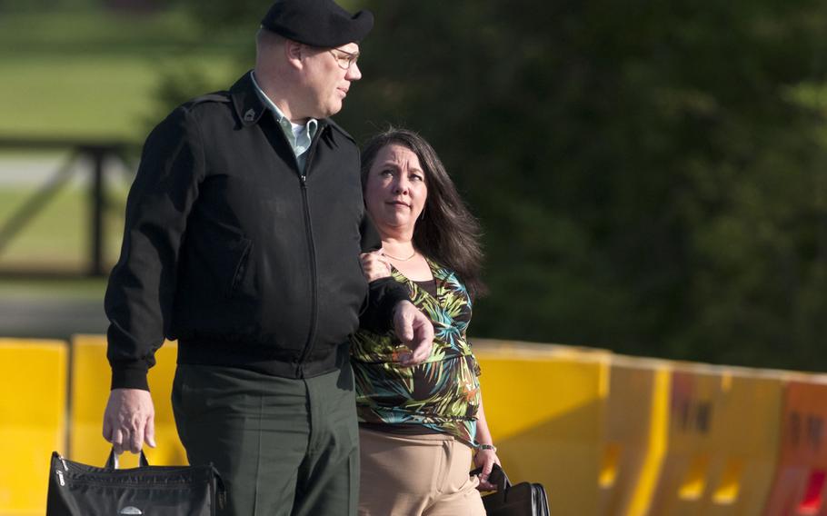 Master Sgt. Timothy Hennis and his wife, Angela Hennis, walk to the Fort Bragg, N.C., courthouse for his murder trial Thursday, April 8, 2010. Hennis was found guilty of the May 9, 1985, murder of Kathryn Eastburn and her two children.