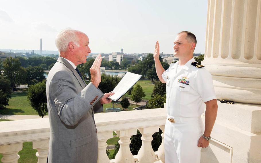 Jonathan Cebik takes the oath for promotion to lieutenant commander, administered by U.S. Rep. Joe Courtney, D-Conn., on Sept. 7, 2016.