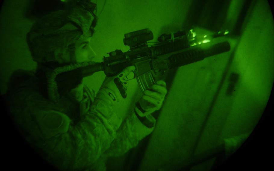 An American soldier is photographed through a night-vision goggle lens while conducting a raid in Baghdad in November 2007.