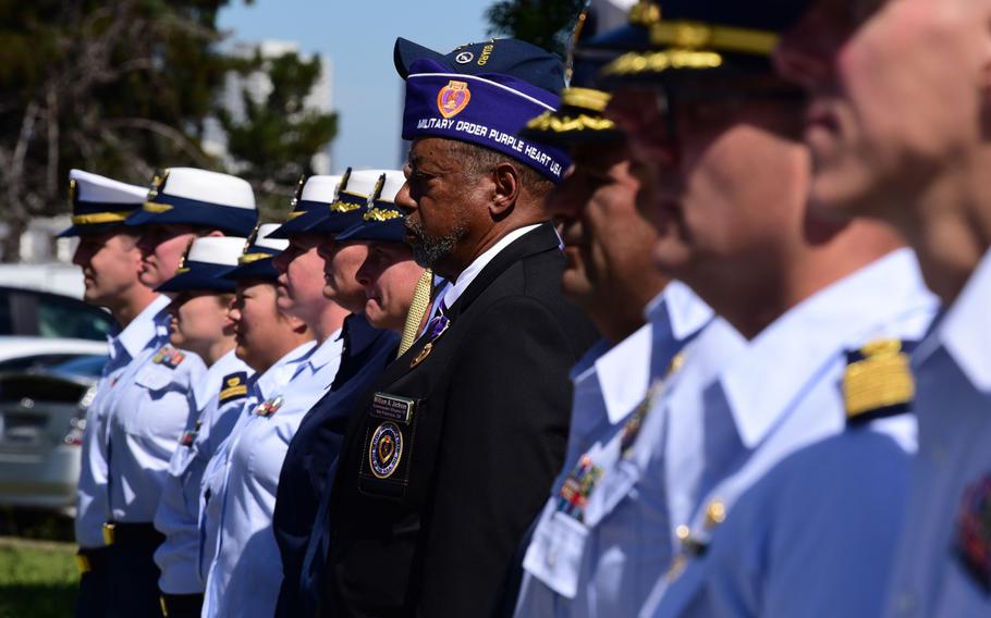 Servicemembers and guests stand during a ceremony on Coast Guard Island in Alameda, Calif., Sept. 3, 2019, where the service posthumously presented Purple Heart medals to families of two Coast Guardsmen who died when the Coast Guard Cutter Tampa was sunk by a German U-boat in Sept. 1918.