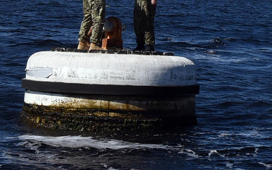 Naval Support Activity Panama City commanding officer Cmdr. Jay Sego re-enlists Boatswain's Mate 1st Class Taylor Baxley atop a mooring buoy in Saint Andrew Bay off Panama City, Fla., Feb. 25, 2019.