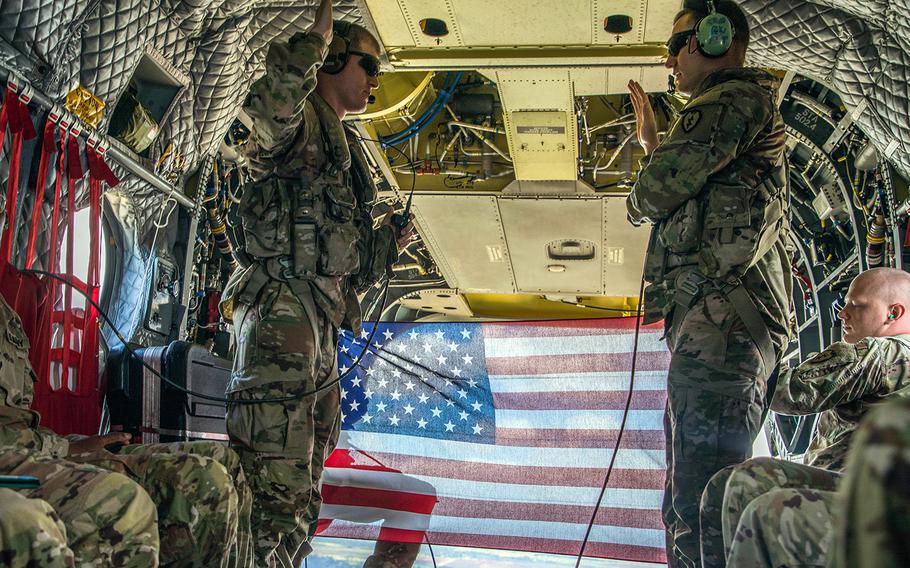 Sgt. Damian Childress, assigned to the U.S. Army 25th Infantry Division, re-enlists inside a CH-47 Chinook helicopter as it flies over the island of Oahu, Hawaii, Aug 13, 2019.