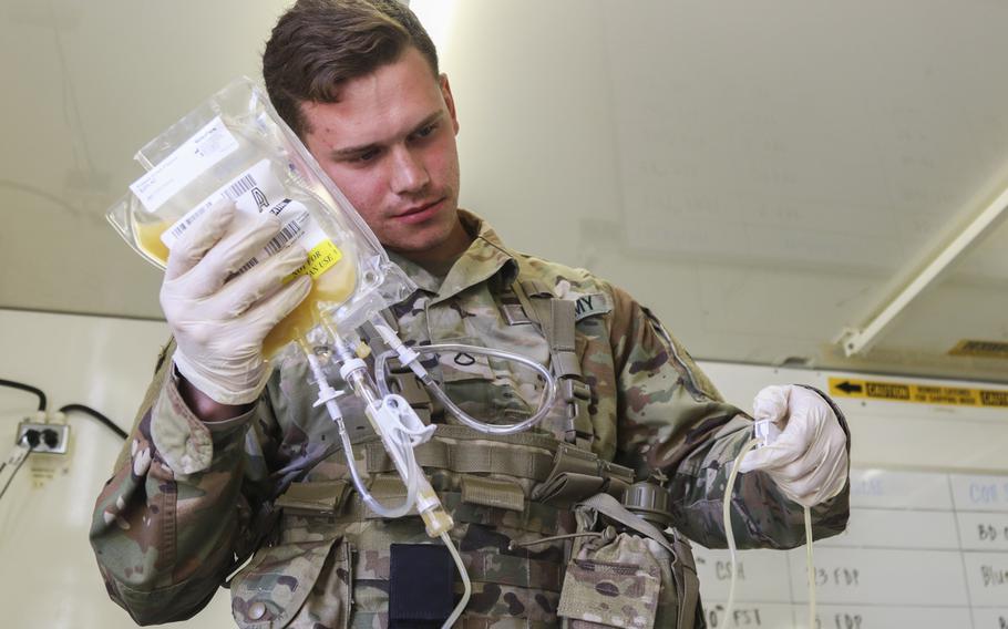 Pfc. Jaritt Louthan, a medical lab technician with the 432nd Blood Support Detachment, 28th Combat Support Hospital, 44th Medical Brigade, re-hydrates freeze-dried plasma during an airdrop test on Sept. 19, 2019 at Fort Bragg, N.C.