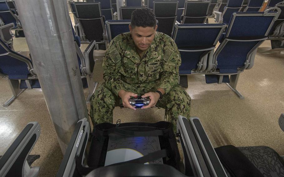 Petty Officer 2nd Class Emmanuel Velazquez of Carolina, Puerto Rico, plays a video game aboard the USNS Spearhead somewhere in the Atlantic Ocean, Aug. 22, 2018.