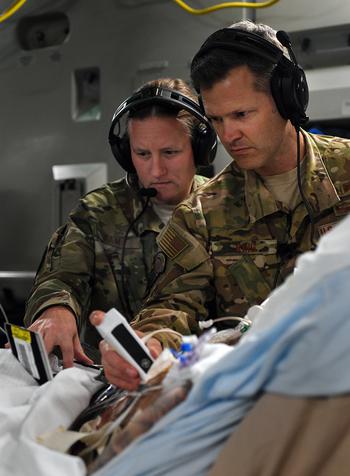 Lt. Col. Valerie Sams, a trauma surgeon with the 59th Medical Wing at Joint Base San Antonio, Texas, and Lt. Col. Scott King, a physician from the 86th Aeromedical Evacuation Squadron at Ramstein Air Base, Germany, perform an ultrasound on a critically wounded service member during a nonstop flight from Afghanistan to Texas, Aug. 18, 2019.