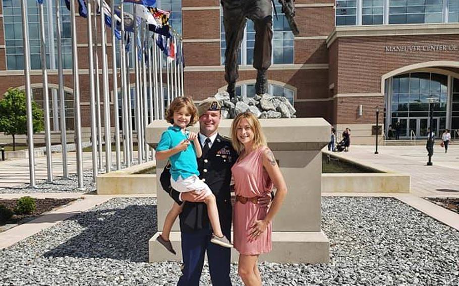 Staff Sgt. Ryan Davis stands with wife Asia Davis and son Knox Davis in an undated family photo taken in front of the Army's Maneuver Center of Excellence at Fort Benning, Ga.