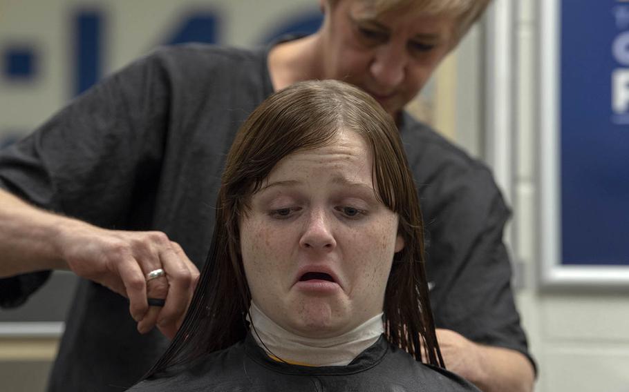 A Navy recruit gets her hair cut at Recruit Training Command Great Lakes, Ill., Sept. 19, 2018.