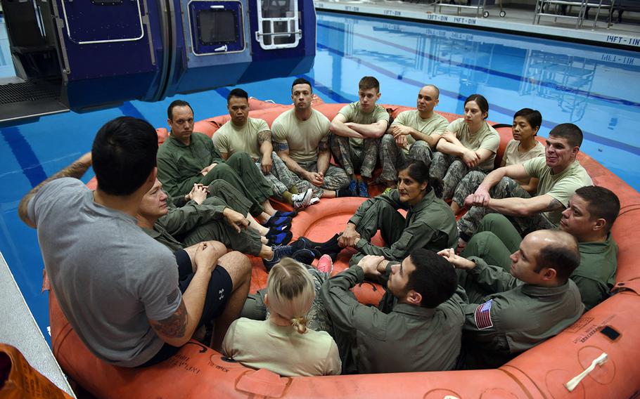 NASA astronauts sit in with a class of survival school students being briefed on life raft procedures at Fairchild Air Force Base, Wash., Feb. 10, 2017.