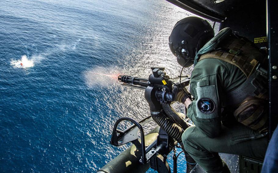 Marine Sgt. Cade Allen, of Bartlesville, Okla., fires a GAU-17 mingun at a fast inshore attack craft during a live-fire exercise on board a UH-1Y Huey assigned to Marine Medium Tiltrotor Squadron 163 (Reinforced). This photo was part of a portfolio that earned Petty Officer 2nd Class Kyle Carlstrom honors as the Defense Media Activity's military photographer of the year for 2019.