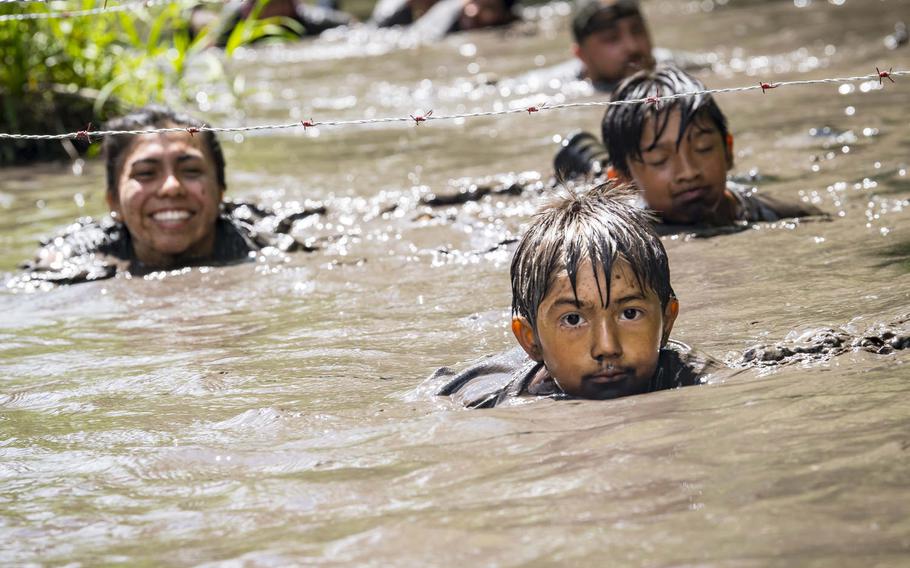 Moody Mud Run participants swim under a barbed wire obstacle on May 4, 2019, in Ray City, Ga., in this photo that was part of a portfolio that earned Airman 1st Class Eugene Oliver honors as the Air Force's military photographer of the year.