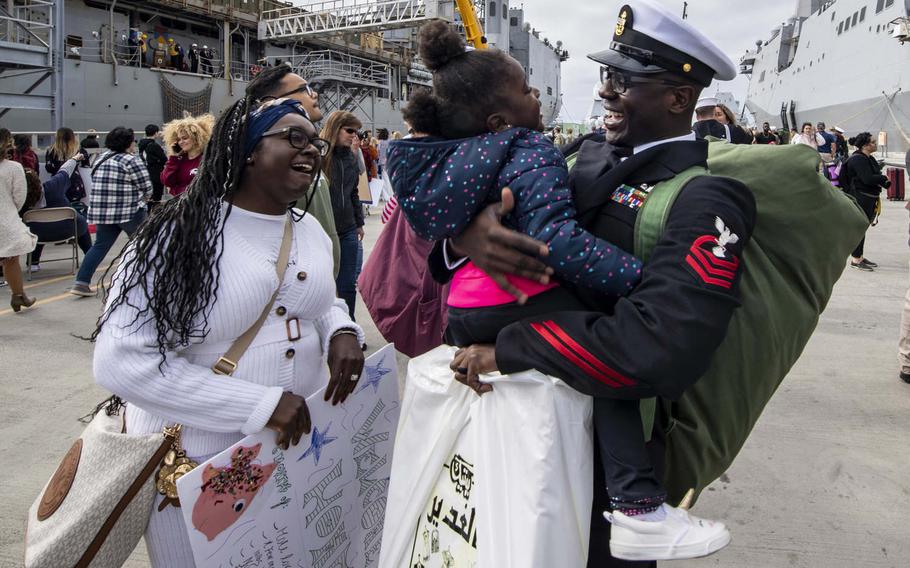 Chief Petty Officer Jonathan Kwakye, of Accre, Ghana, assigned to the amphibious transport dock ship USS John P. Murtha, reunites with his family during a homecoming gathering at Naval Base San Diego on Nov. 27, 2019. This image was part of a portfolio that earned Petty Officer 2nd Class Kyle Carlstrom honors as the Defense Media Activity's military photographer of the year for 2019.