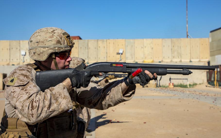 A U.S. Marine pumps a 12-gauge shotgun on a familiarization range in Baghdad, Iraq, May 16, 2020. The Corps is looking to develop an electroshock round, fired from a shotgun, that could hit targets a football field away.