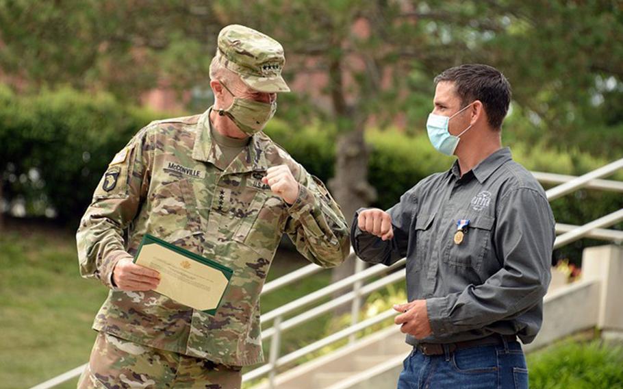 Retired Master Sgt. David Royer, right, exchanges an elbow bump with Chief of Staff of the Army Gen. James McConville after receiving the Soldier?s Medal on July 16, 2020. Royer was awarded the Army's highest peacetime honor for stopping an active shooter on Centennial Bridge in Leavenworth, Kan., in late May.