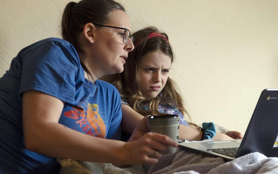 A mother and daughter read over a school assignment inside their home at Kaiserslautern, Germany, April 14, 2020.