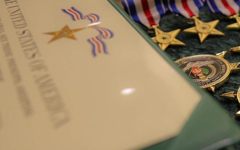 A Silver Star Medal certificate and three of the medals, along with a challenge coin and other medals awarded on Aug. 21, 2020, at a ceremony at Eglin Air Force Base, Fla., recognizing acts of combat bravery during the six-month deployment of 1st Battalion, 7th Special Forces Group (Airborne), in Afghanistan from July 2019 to January 2020.