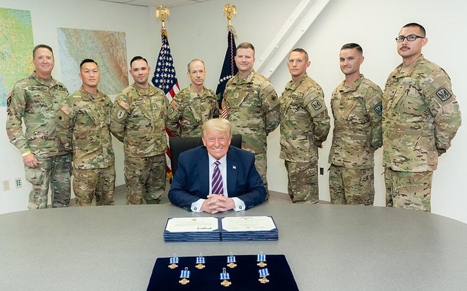 President Donald Trump, center, poses with two California National Guard helicopter crews he awarded the Distinguished Flying Cross on Monday, Sept. 14, 2020, for their heroic rescue of about 240 adults and children trapped by the Creek Fire near Fresno, Calif., on Sept. 5, 2020. In back, from left to right, are California's assistant adjutant general Maj. Gen. Matthew P. Beevers, Black Hawk crew chief Warrant Officer 1 Ge Xiong, pilot Chief Warrant Officer 2 Irvin Hernandez, pilot-in-command Chief Warrant Officer 5 Kipp Goding, Chinook pilot-in-command Chief Warrant Offcier 5 Joseph Rosamond, pilot Chief Warrant Officer 2 Brady Hlebain, flight engineer Sgt. Cameron Powell, flight engineer Sgt. George Esquivel.