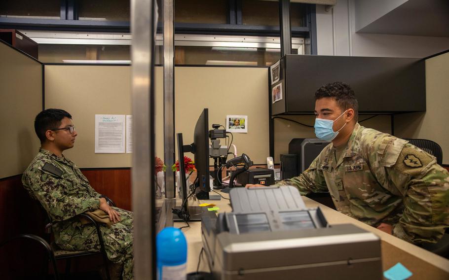Pvt. Aaron Byrd, right, of the 25th Division Sustainment Brigade, helps Petty Officer 2nd Class Nick Ishiharapuzon get a new Common Access Card at the Soldier Support Center at Schofield Barracks, Hawaii, Aug. 20, 2020.