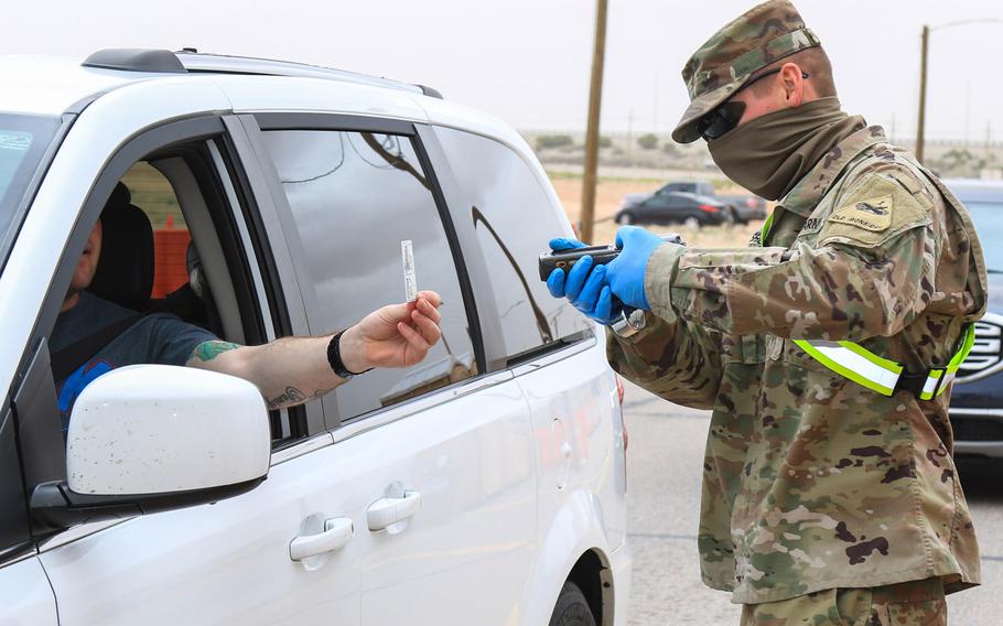 Pfc. Ryan Chisholm checks an ID at Fort Bliss, Texas, March 27, 2020. Service members and others with Common Access Cards that expired during the coronavirus pandemic or are about to expire must renew them by September 30, Defense Department guidance issued this month said.